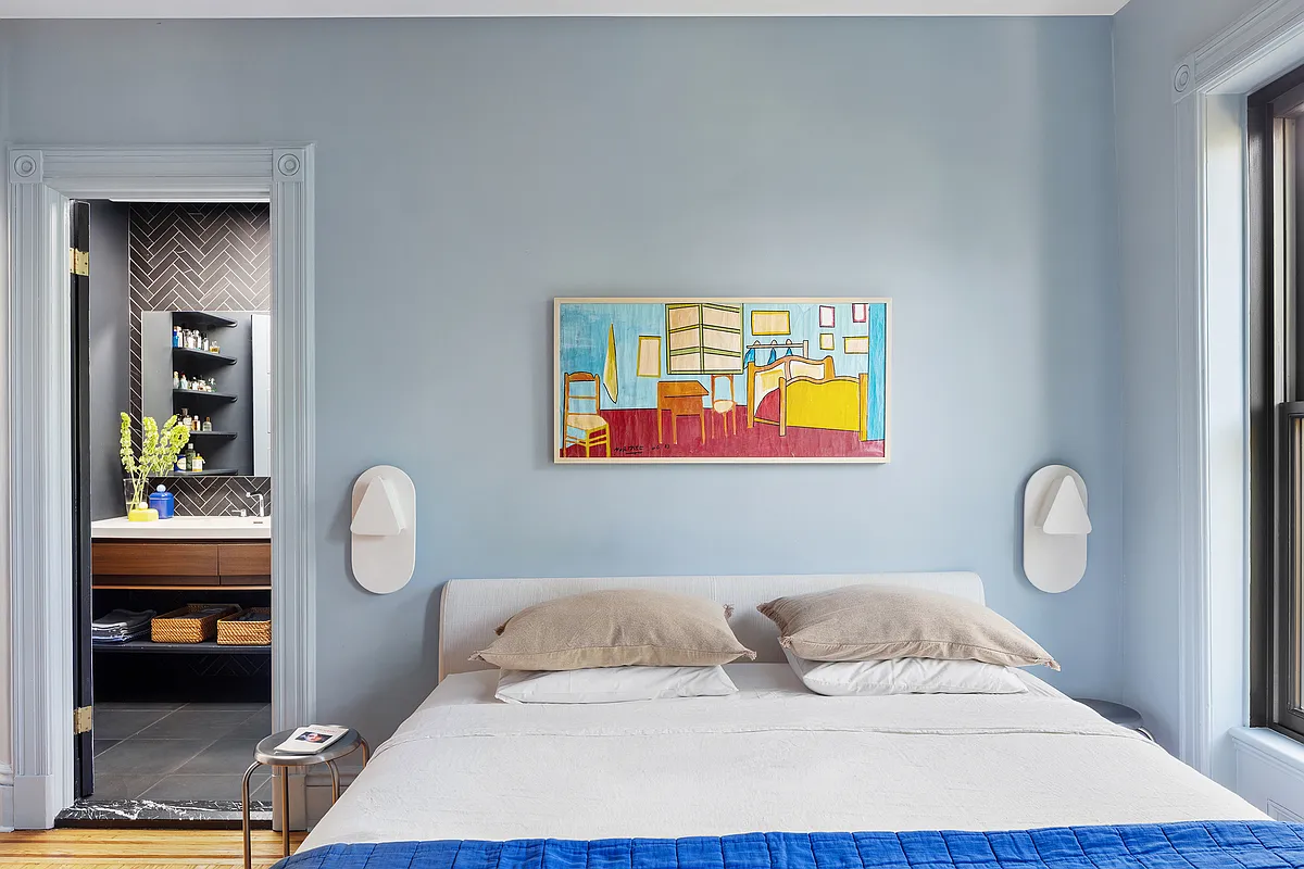 bedroom with blue walls and view into en suite bath