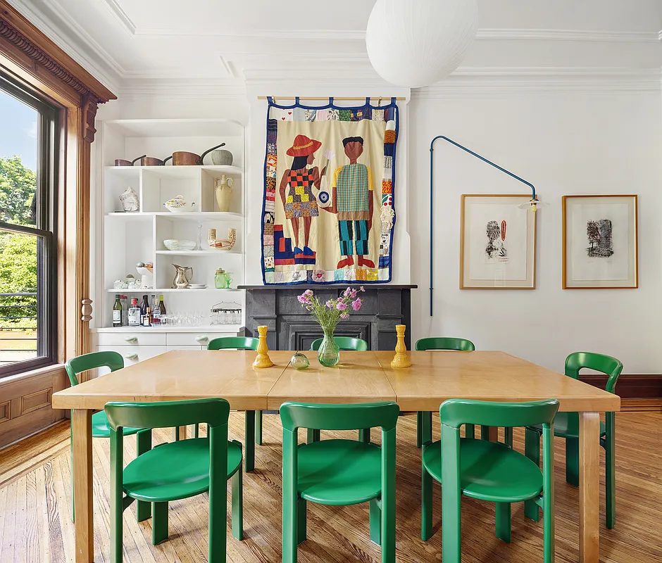 dining area with a stone mantel, table with green chairs