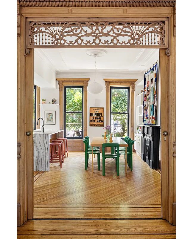 doorway with pocket doors and fretwork and view into dining room and kitchen
