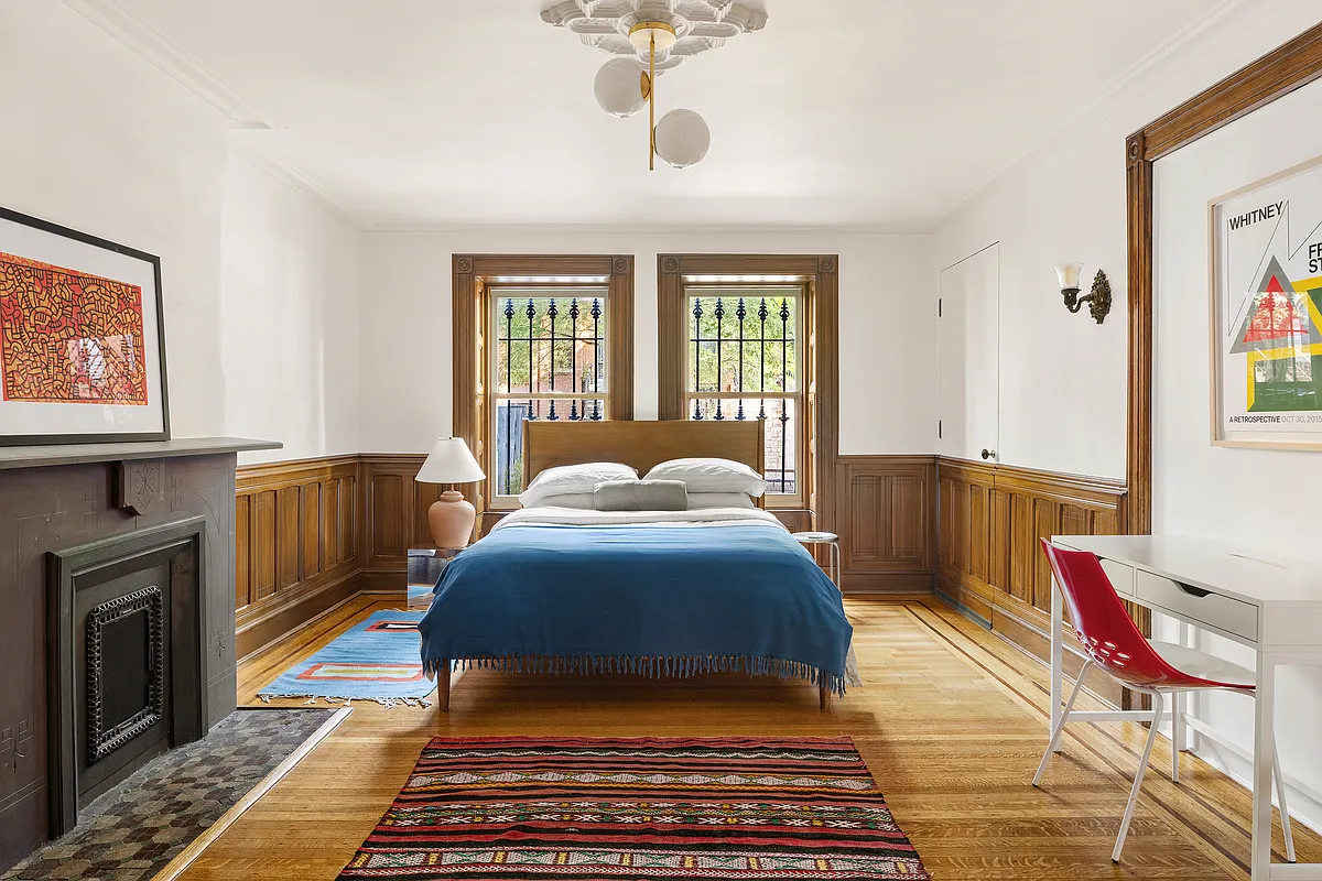 garden level bedroom with wainscoting, stone mantel