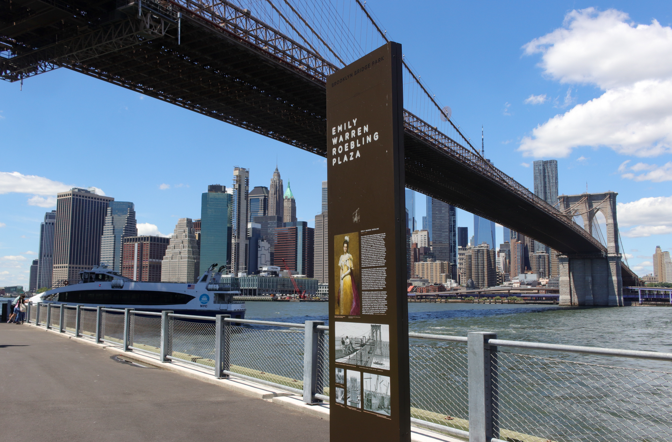 informational sign about emily warren roebling placed with a view of the brooklyn bridge