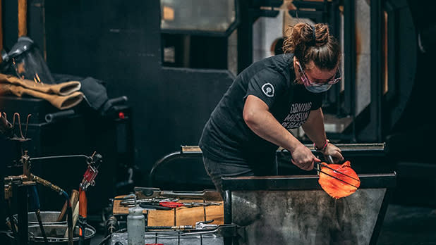 A person conducts a glass-making demonstration at the Corning Museum of Glass