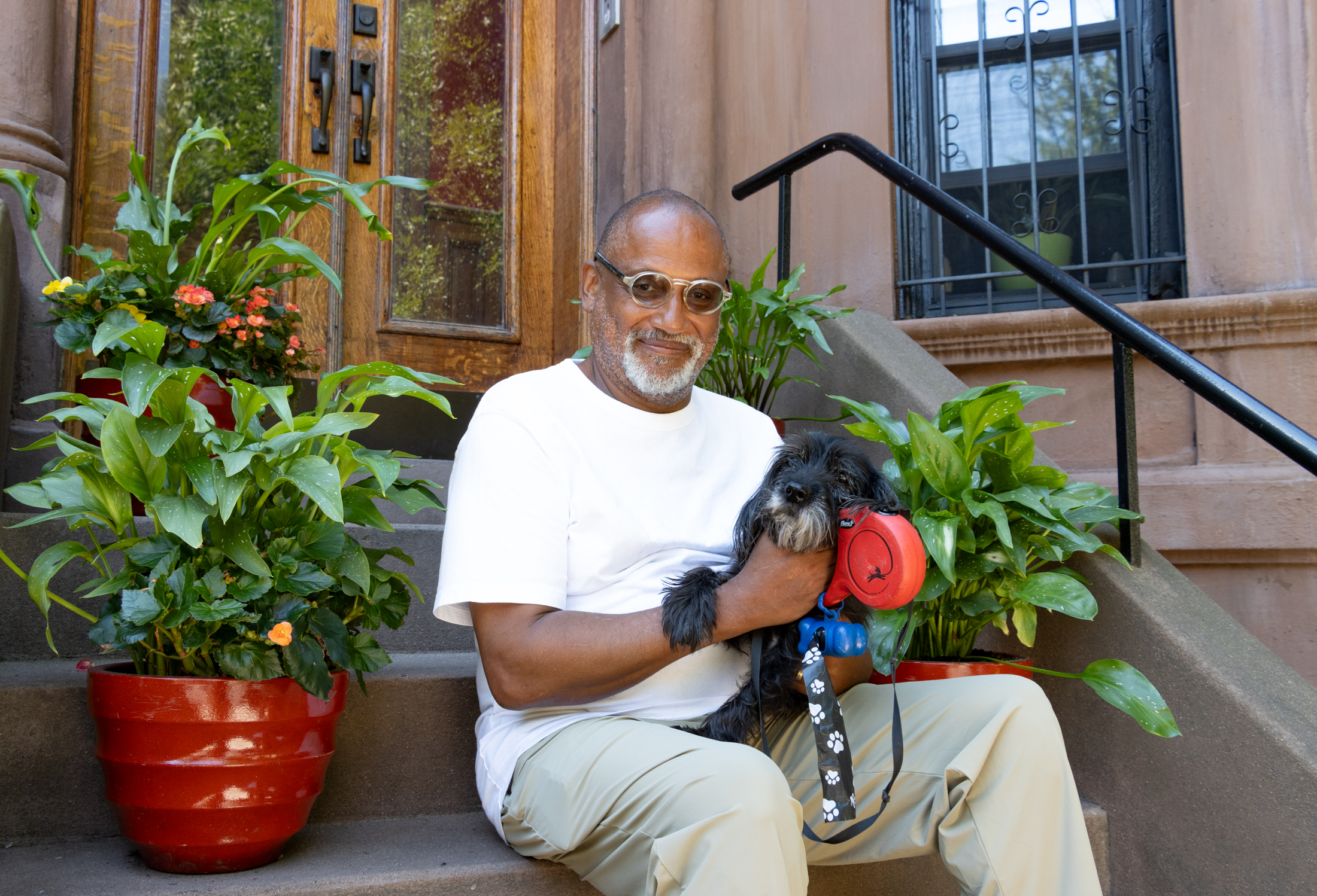 person on stoop with planters and a dog