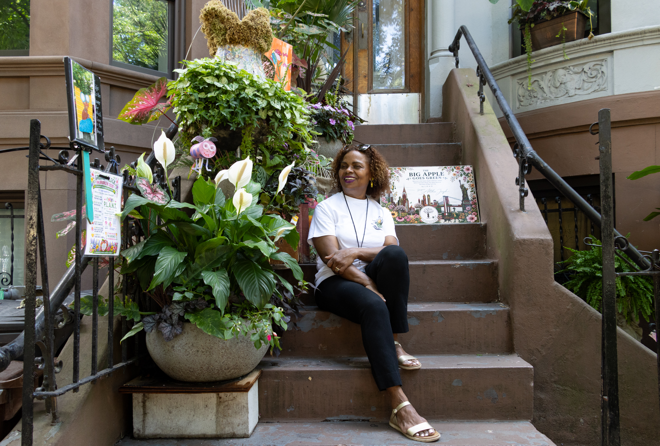 person sitting on stoop with planters