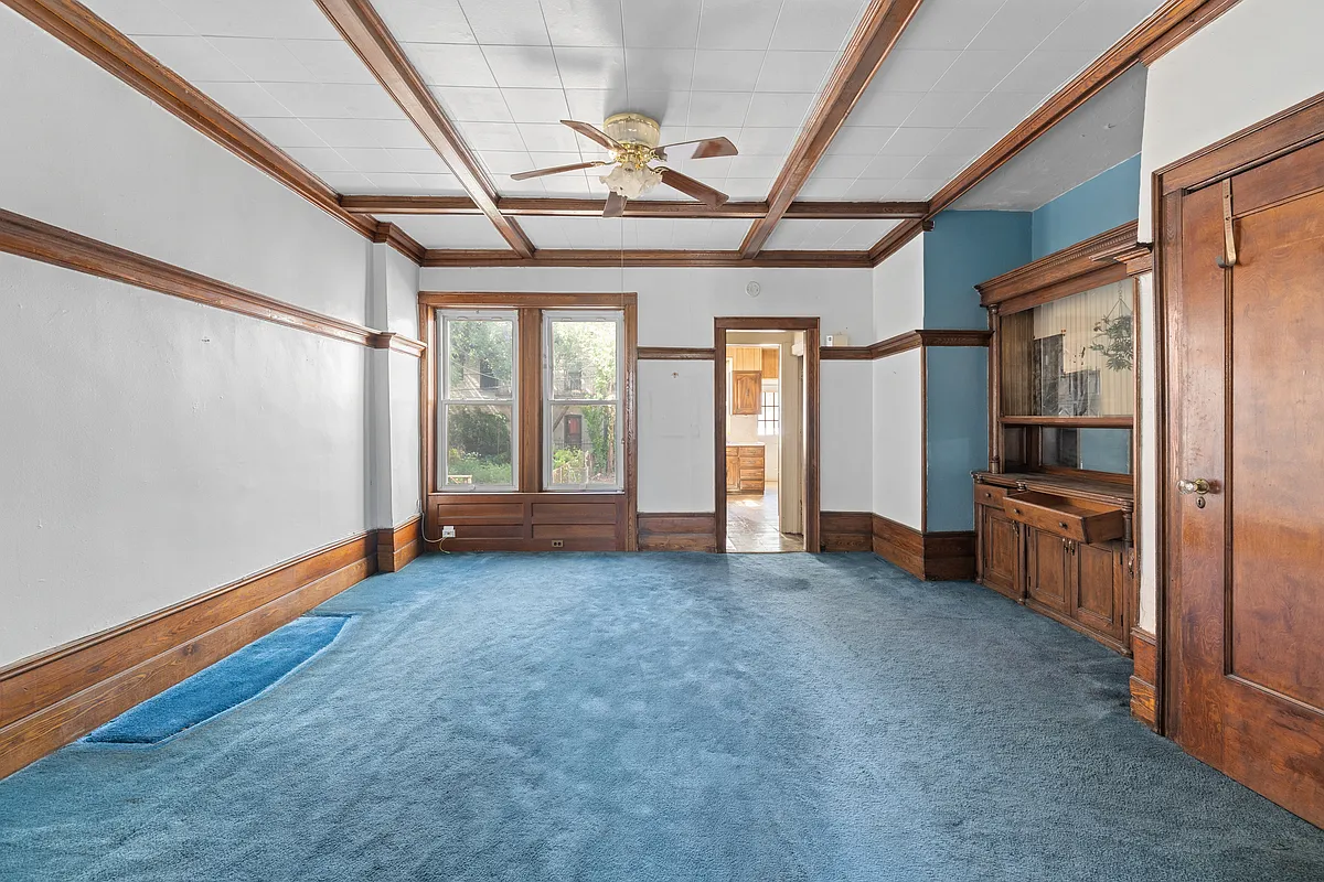 dining room with beamed ceiling, built-in and blue carpet