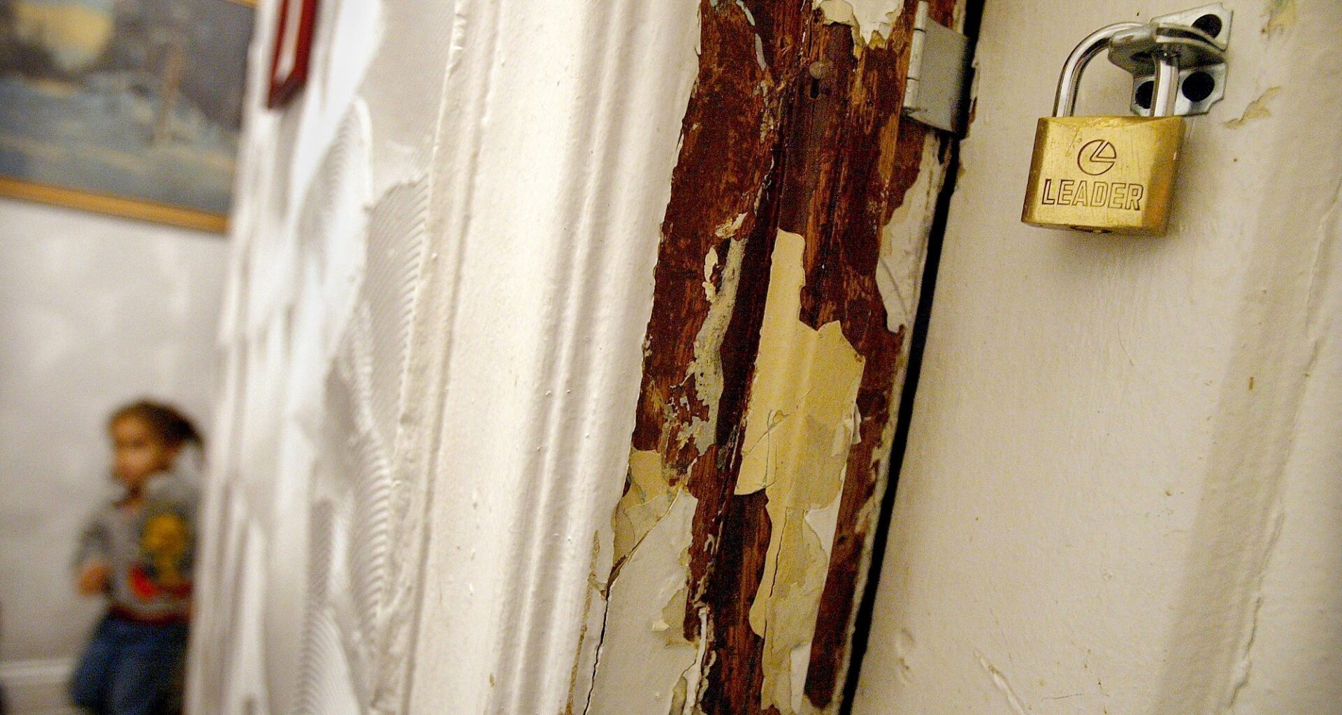 Flaky paint in the foreground with a child in the background
