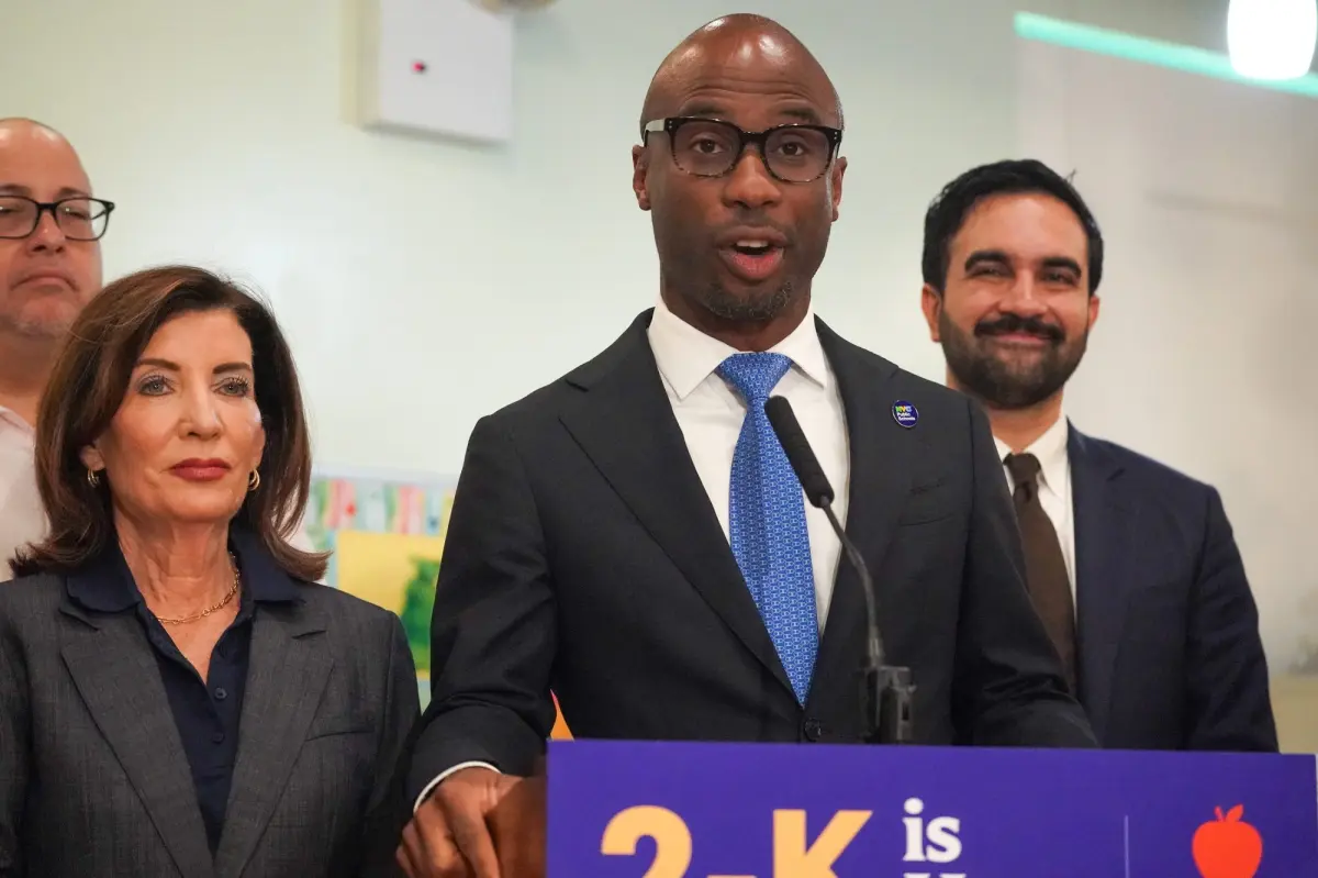 Kamar Samuels, NYC education chancellor, standing next to Mayor Mamdani and Governor Hochul.