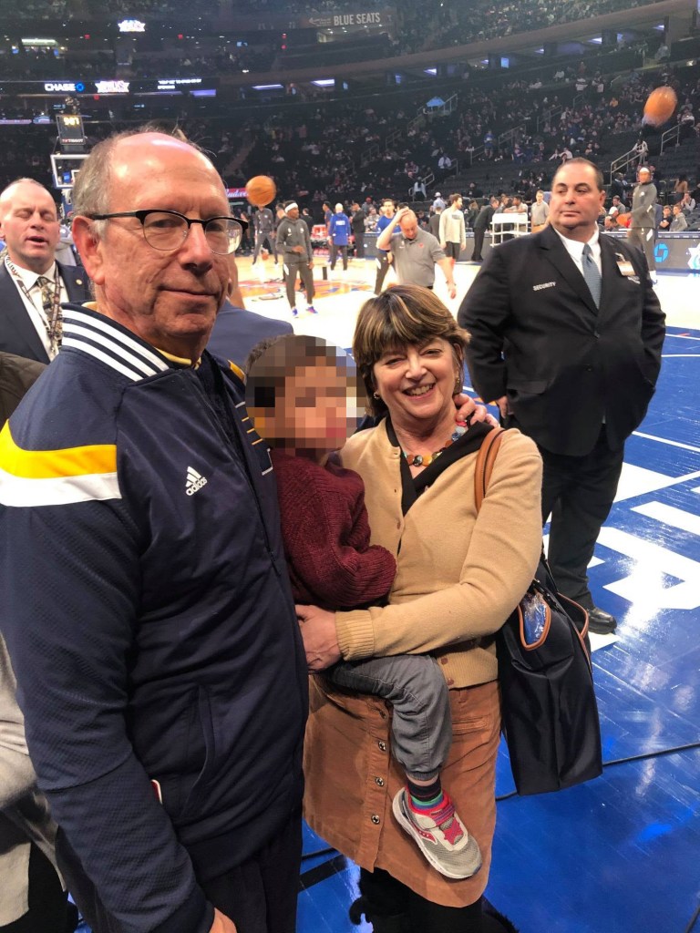 Michael Trager and Cara Trager with a child at a sports arena.
