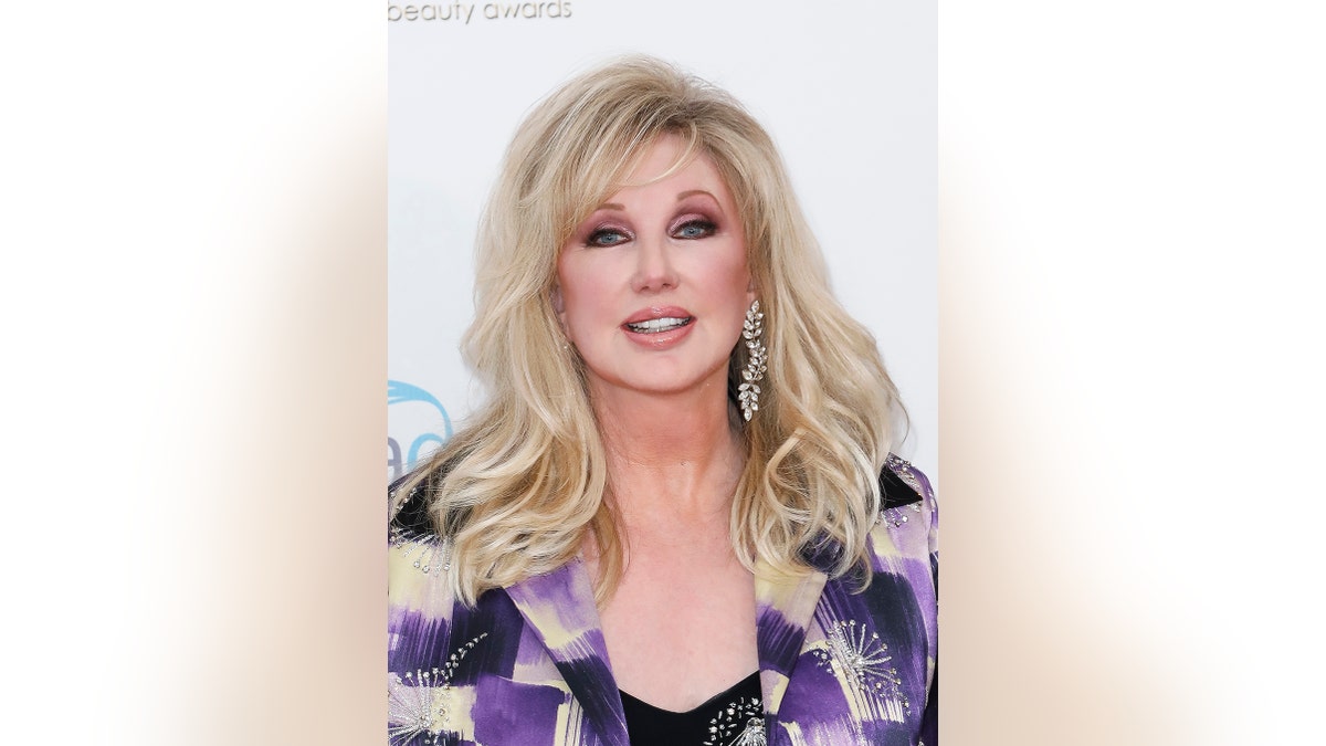 A close-up of Morgan Fairchild wearing a purple blazer.