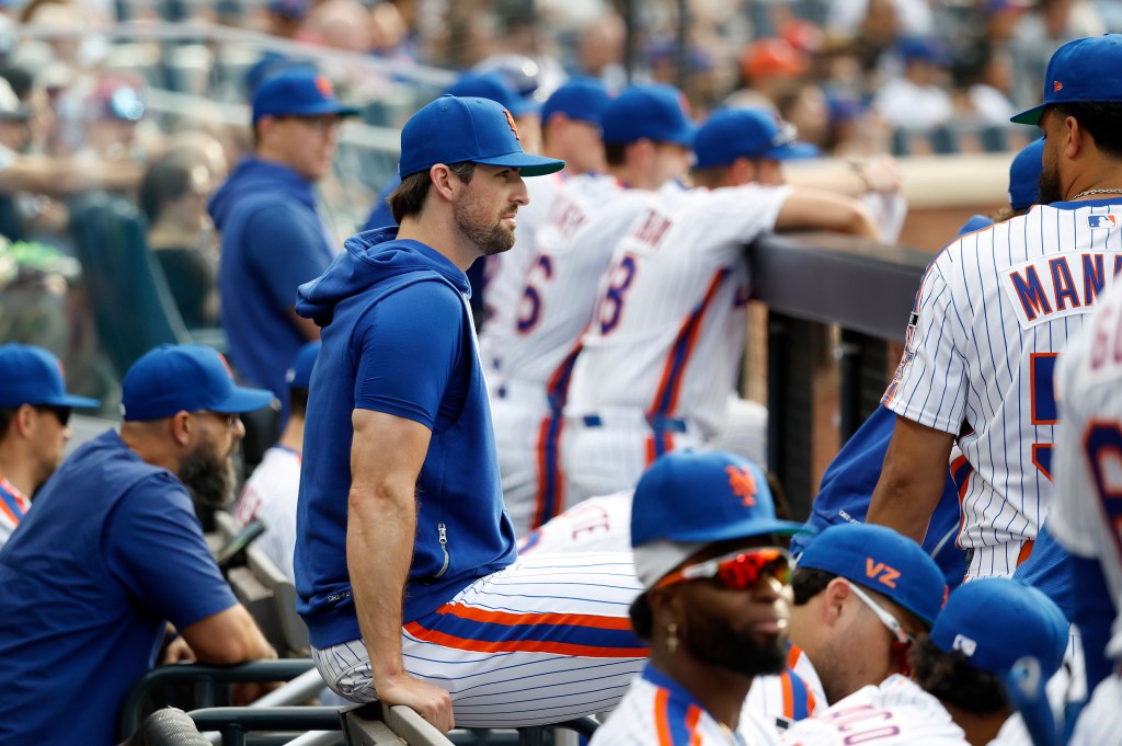New York Mets player Clay Holmes sits in the dugout during a game against the Miami Marlins.