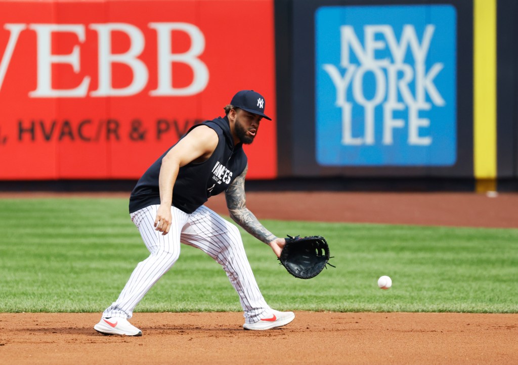 New York Yankees first baseman Luis García Jr. fielding a baseball on the infield.