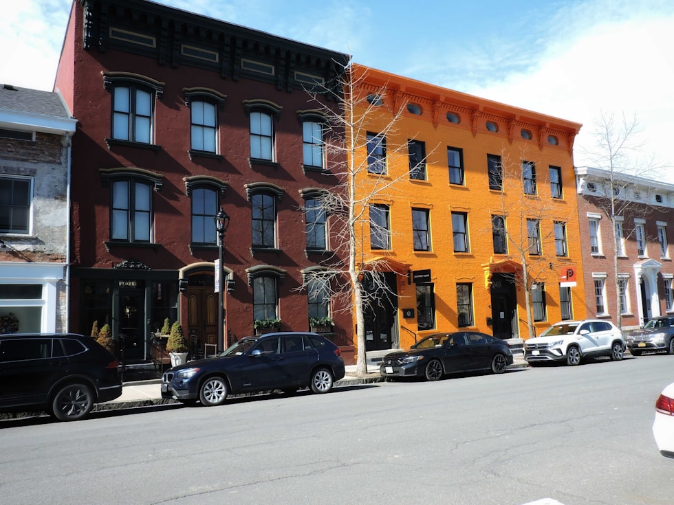 Colorful row houses stand on a city street