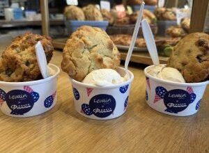 three cups each with a scoop of ice cream and a big cookie