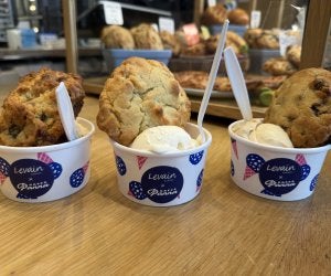 three cups each with a scoop of ice cream and a big cookie