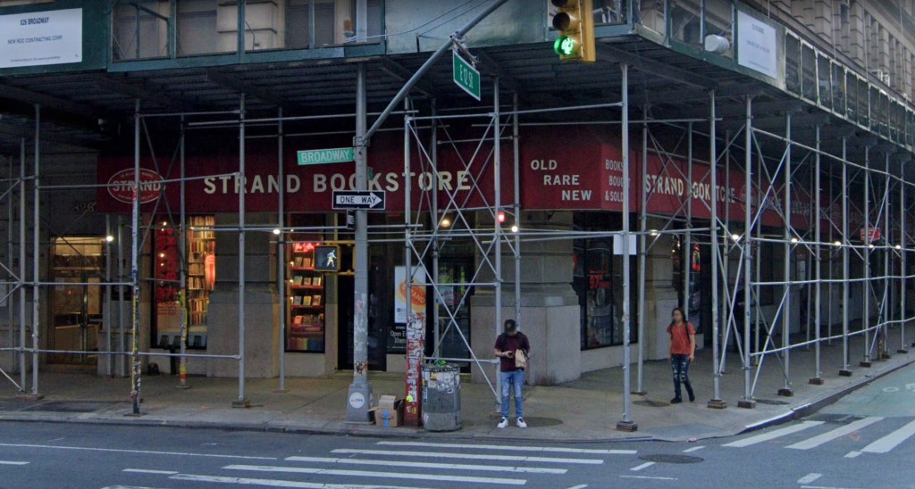 The Strand Bookstore with red awnings and scaffolding in front, showing the street sign for Broadway and E 12th St.