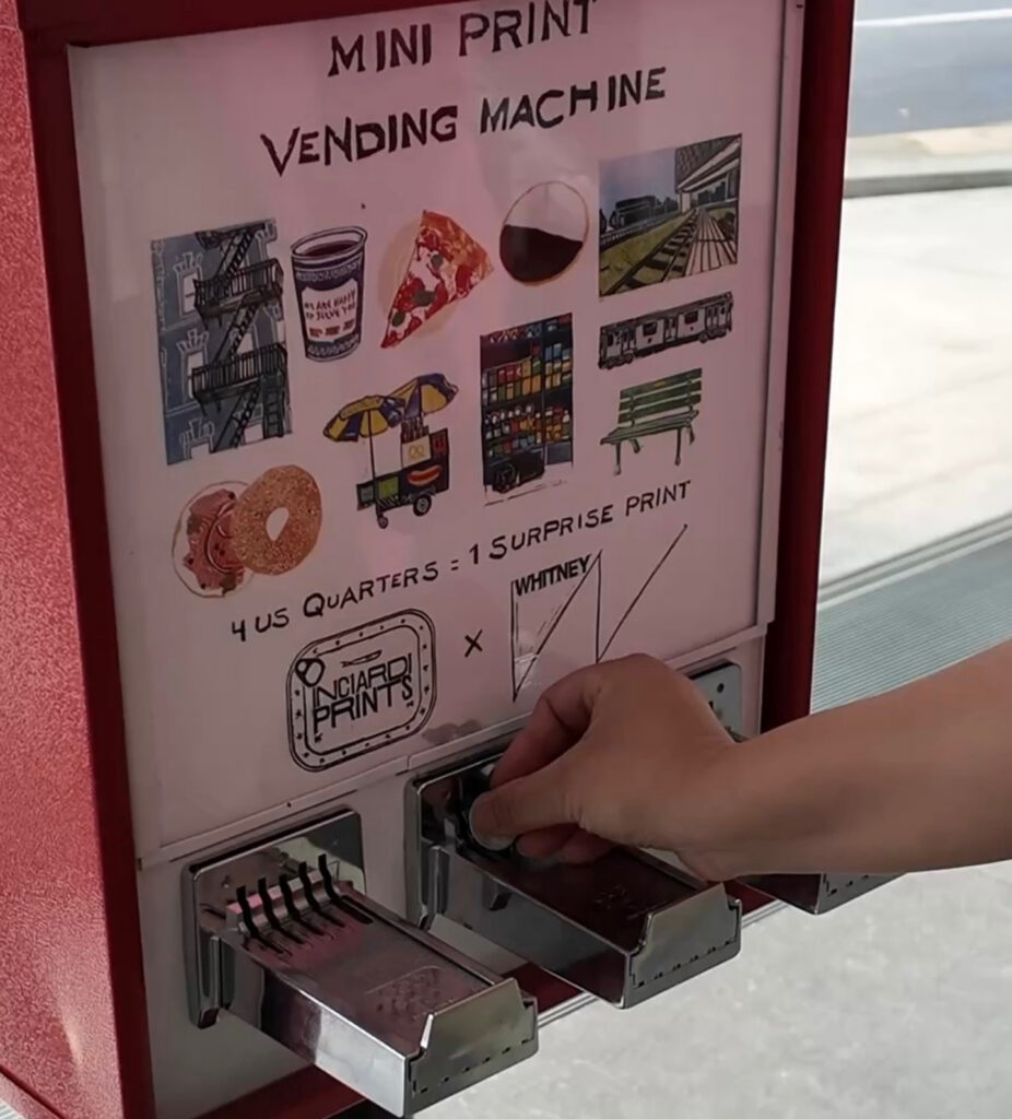 A hand inserts a coin into a red vending machine labeled Mini Print Vending Machine, which dispenses surprise prints for four U.S. quarters. Illustrations of prints, food, and city scenes are displayed above the coin slots.
