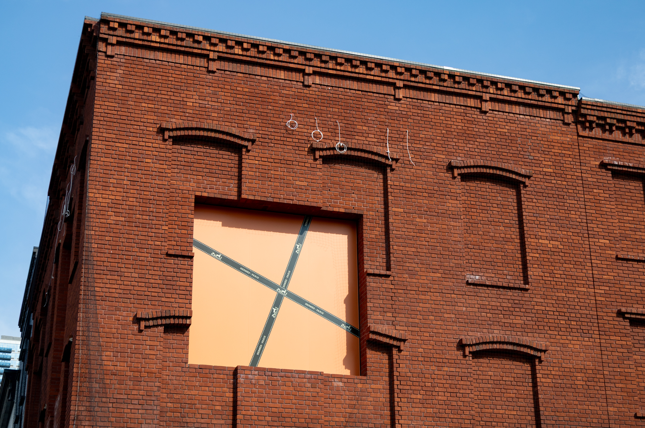 brick building with orange paper in windows