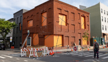 brick building with orange paper in windows