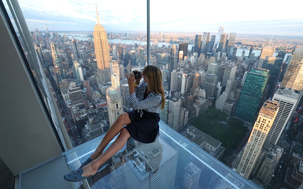 A woman takes pictures as photographers, content creators, and visitors attend an event to celebrate World Photography Day at sunrise at SUMMIT One Vanderbilt in New York City on Wednesday, August 19, 2026. (AFP)