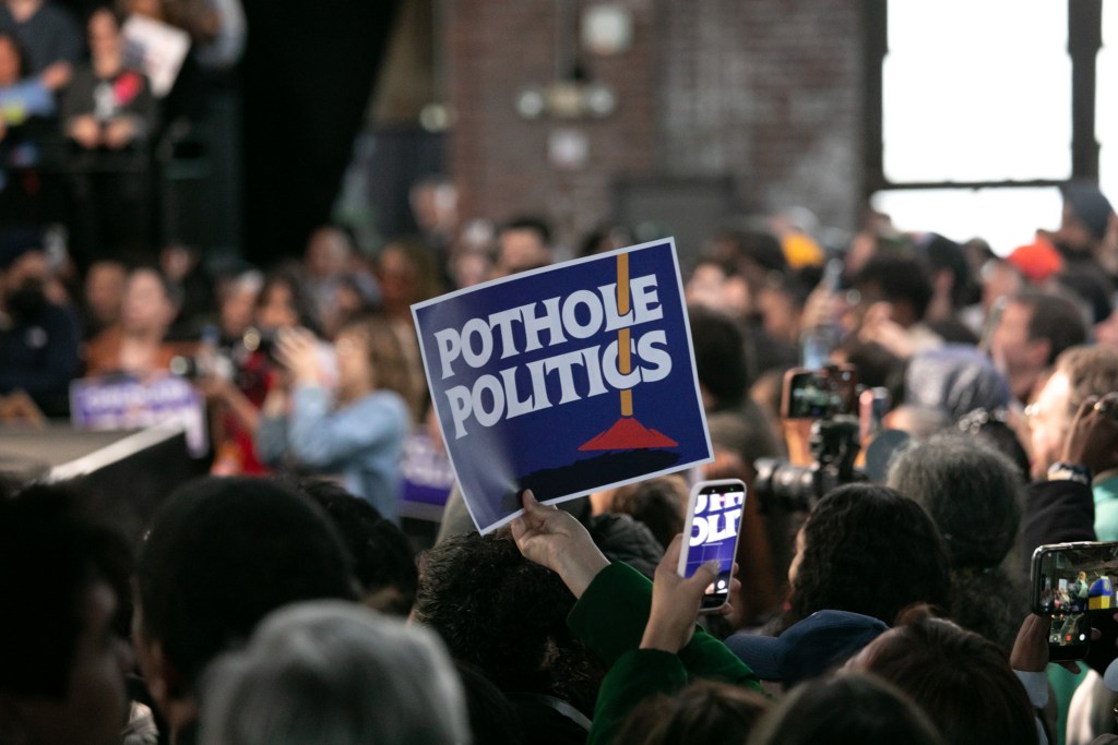 City workers and supporters held signs at the Knockdown Center in Queens supporting Mayor Zohran Mamdani’s “pothole politics” after his first 100 days in office,