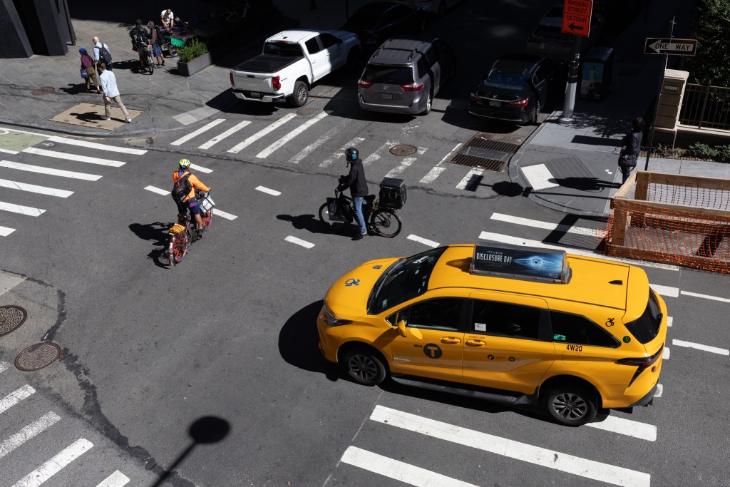 Car and cyclists converge at a Lower Manhattan intersection,