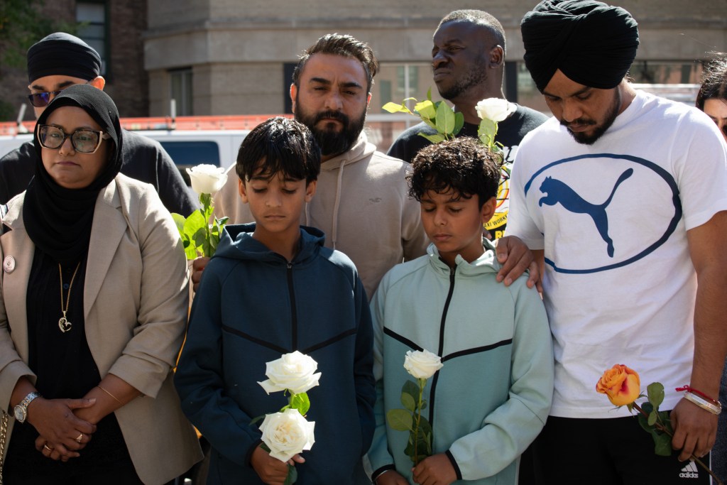 A friend of Jagjit Singh consoles his twin 10-year-old sons at a West Village memorial where Singh was found dead in his cab,