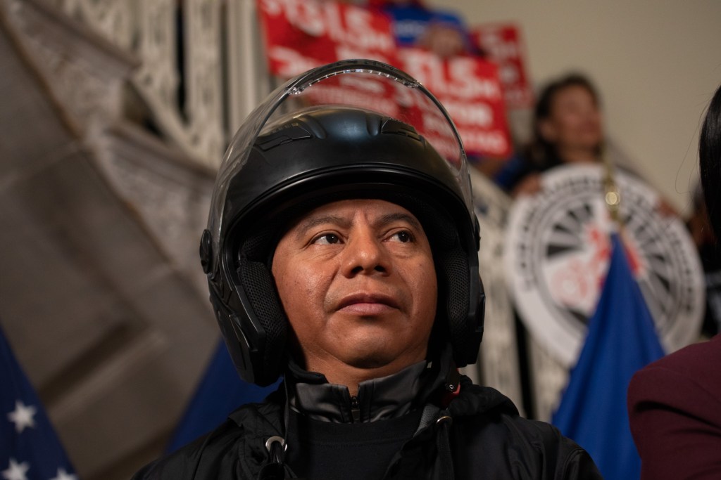 Deliverista Rosendo Tacam prepares to speak at City Hall about a $131 million settlement with DoorDash over wage theft,