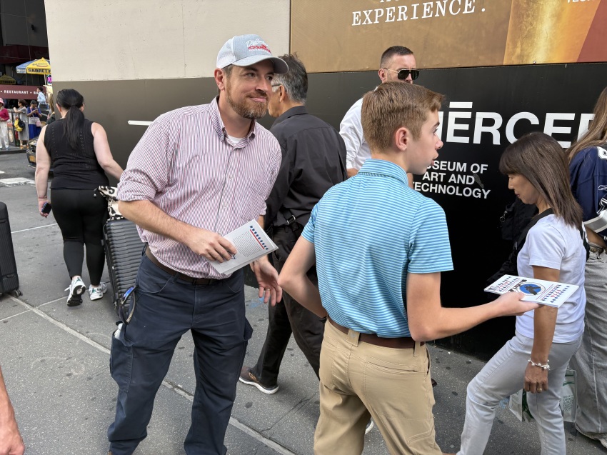 Pastor Jonathan Osborne (L) of Free Will Baptist Church in Rockingham, North Carolina, and his son distribute tracts in Lower Manhattan, New York, on Sept. 11, 2026.