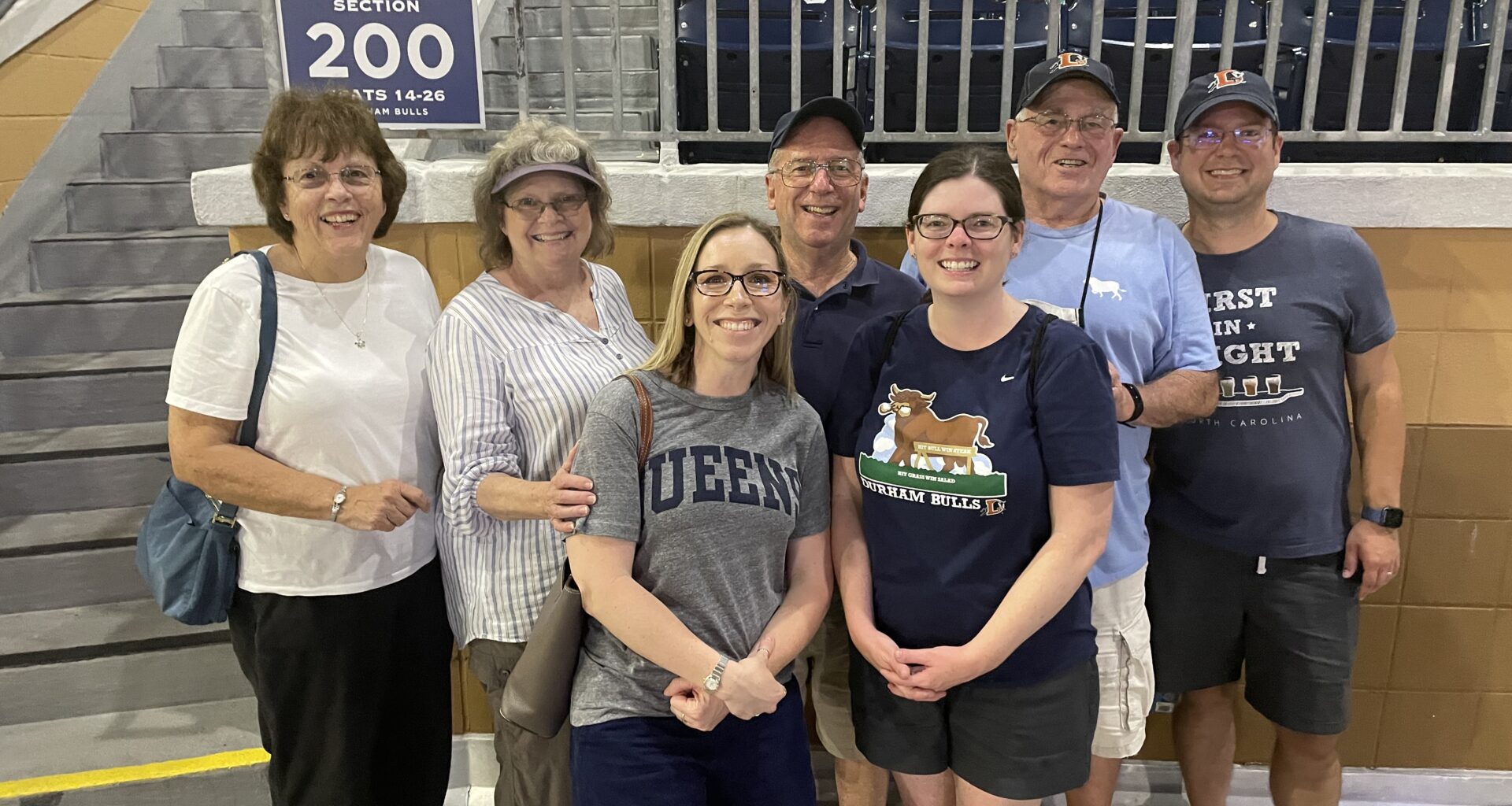 Fleming and Thoman stand in a stadium with five family members