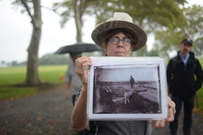 Urban Park Ranger Leonora Todaro shows tourgoers images of incarcerated workers conducting burials.