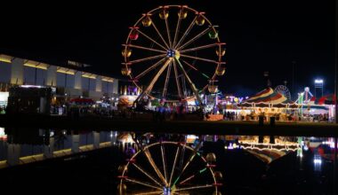 The ferris wheel reflects on the pond at the State Fair.