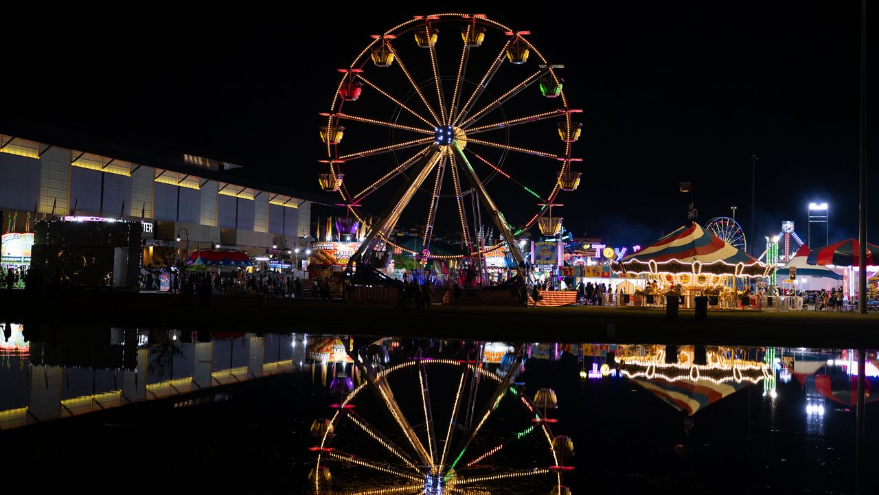 The ferris wheel reflects on the pond at the State Fair.