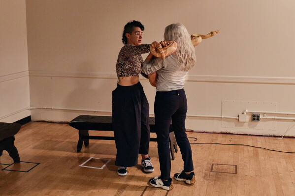 Animal talent expert Nancy Novograd, right, interacts with performance artist Zoe Ziegfeld, who plays the part of a snake charmer, during auditions to select a snake for a part in an adaptation of Mozart’s “Così fan tutte," at the Metropolitan Opera in New York, Friday, Aug. 28, 2026. (AP Photo/Andres Kudacki)