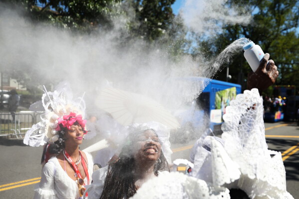 Members of the Belmont Baby Dolls throw baby powder as they wait for the start of the West Indian Day Parade on Monday, Sept. 7, 2026, in the Brooklyn borough of New York. (AP Photo/Heather Khalifa)