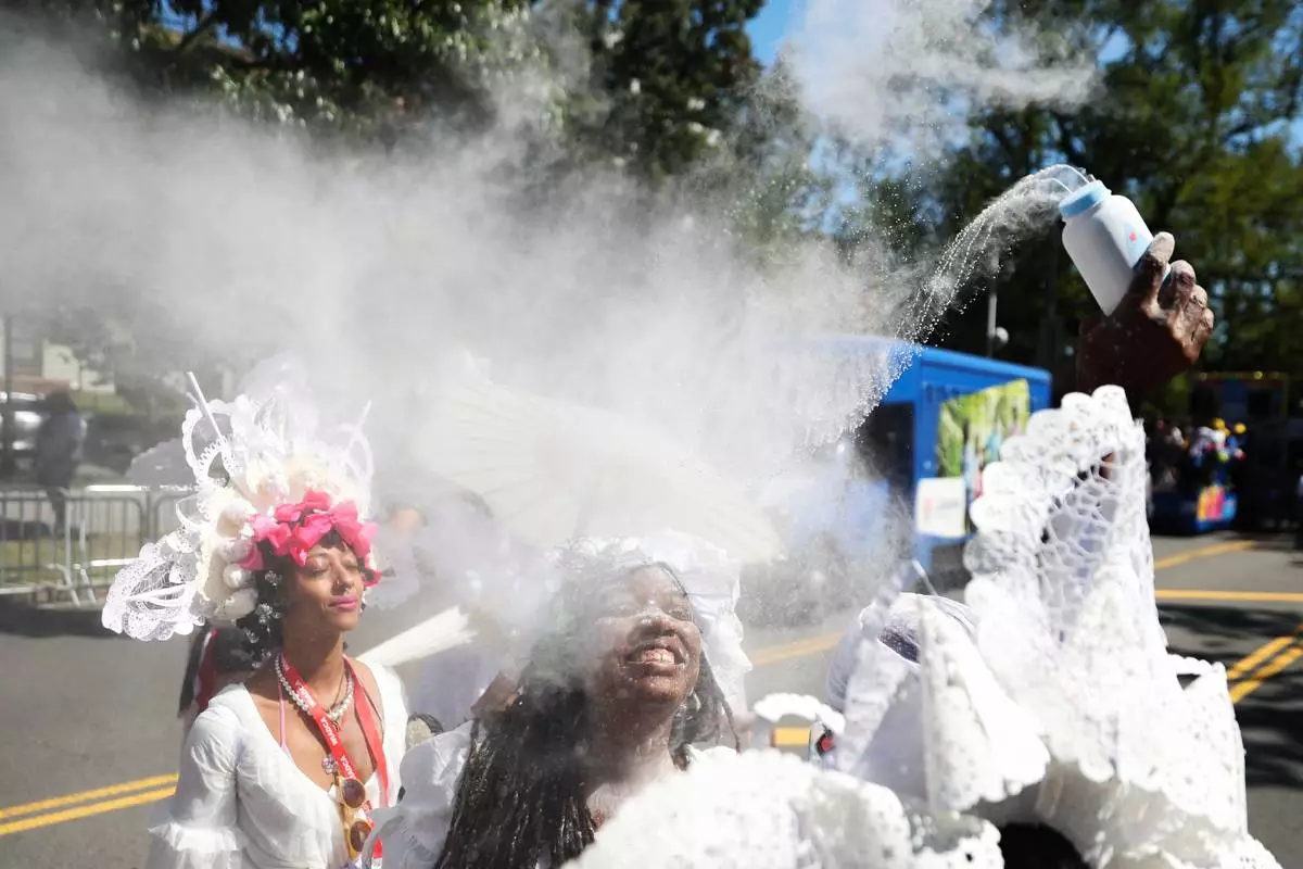 Members of the Belmont Baby Dolls throw baby powder as they wait for the start of the West Indian Day Parade on Monday, Sept. 7, 2026, in the Brooklyn borough of New York. (AP Photo/Heather Khalifa)