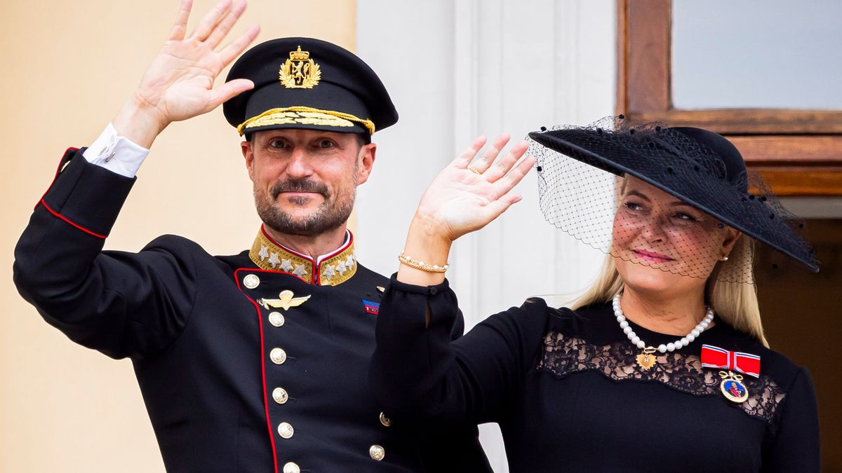 King Haakon VIII and Queen Mette-Marit step onto the balcony as a new reign begins