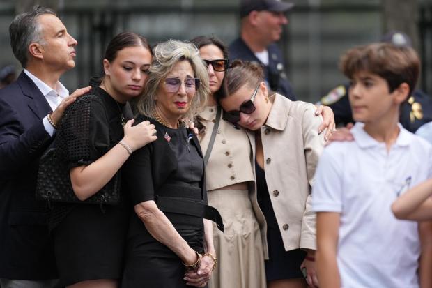 People listen to the U.S. national anthem at the memorial on the 25th anniversary of the September 11, 2001, terrorist attacks, Friday, Sept. 11, 2026, in New York. (AP Photo/Adam Gray, Pool)
