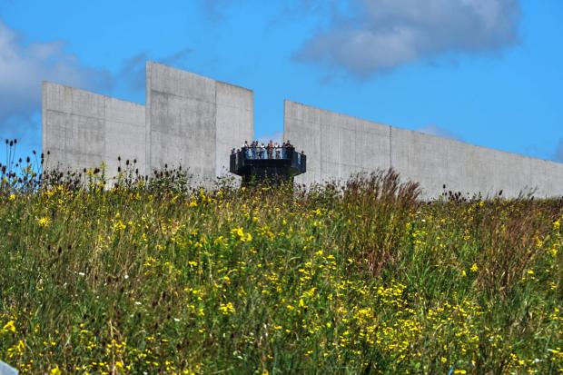 Visitors to the Flight 93 National Memorial in Shanksville, Pa., on Friday, Sept.11, 2026, view the memorial park below from the plane's flight path marked by the separation in the building, as the nation marks the 25th anniversary of the Sept. 11, 2001, attacks. (AP Photo/Gene J. Puskar)