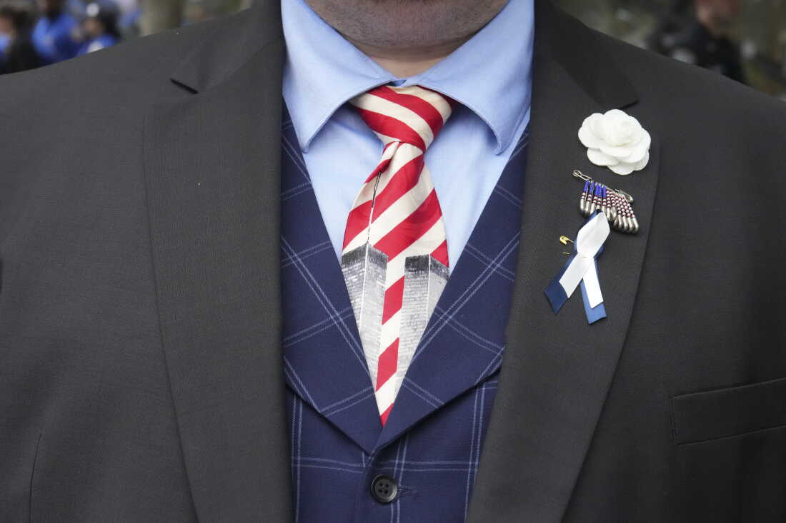 A man wearing a tie depicting the Twin Towers stands ahead of a memorial ceremony to commemorate the 25th anniversary of the September 11th terrorist attacks on the World Trade Center at the National 9/11 Memorial & Museum on Friday.
