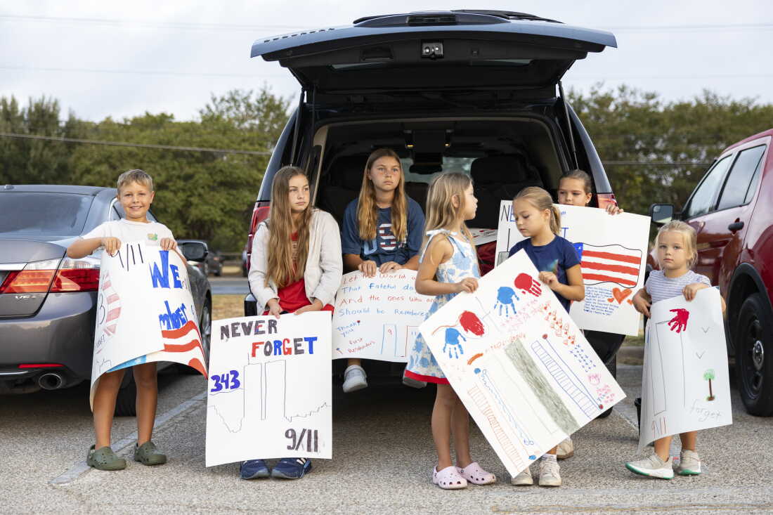 Brooks Penny, 9, Harper Penny, 12, Mabrey Penny, 11, Isla Penny, 6, Charlotte Zwolinski, 6, Kensie Zwolinski, 9, and Madelyn Zwolinski, 4, holds their posters up for the Austin fire fighters during the annual Austin Fire Department Memorial Stair Climb at Pleasant Valley Tower on Friday. Austin firefighters climbed the tower until they reach 1,386, the height of the World Trade Center, to pay tribute to firefighters who died on 9/11.