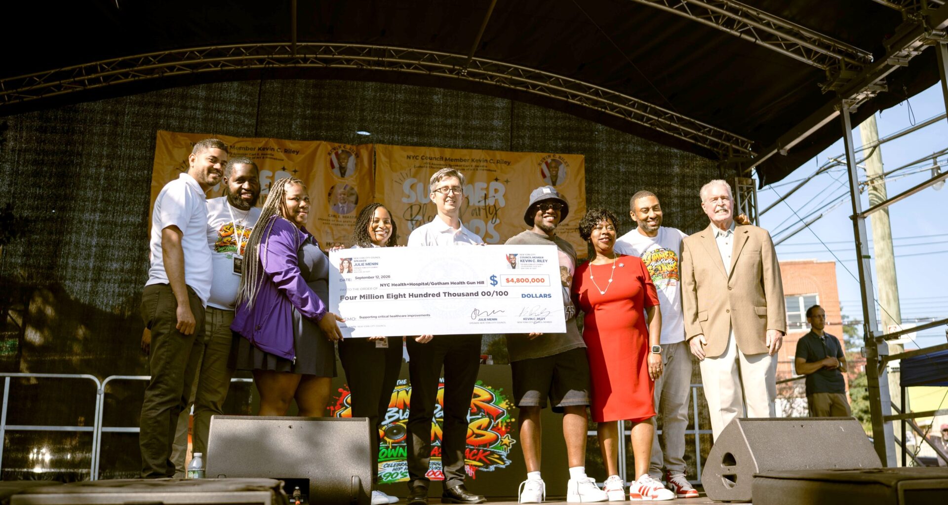 Gotham Health Regional Medical Director Dr. Jeremy O’Connor and Regional Administrator Cari Harewood receive a $4.8 million capital funding check from Council Member Kevin C. Riley to support improvements at Gotham Health, Gun Hill.