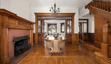 middle parlor with mantel, fretwork, wood floor, stair