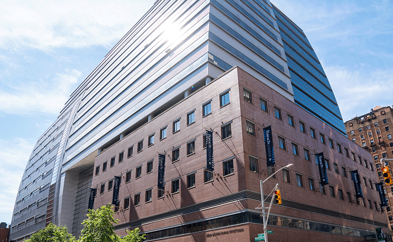Street view image of Baruch College's 14-story Newman Vertical Campus building that features a tiered glass-enclosed atrium.