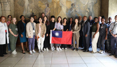 NYC Health + Hospitals/Kings County leadership with the National Taiwan University Hospital delegation in front of the historic Vincent Aderente mural in the hospital’s rotunda
