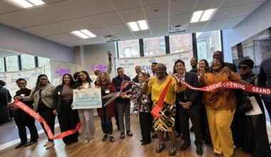 Diverse group of adults celebrates ribbon cutting at Venture House in the Bronx.