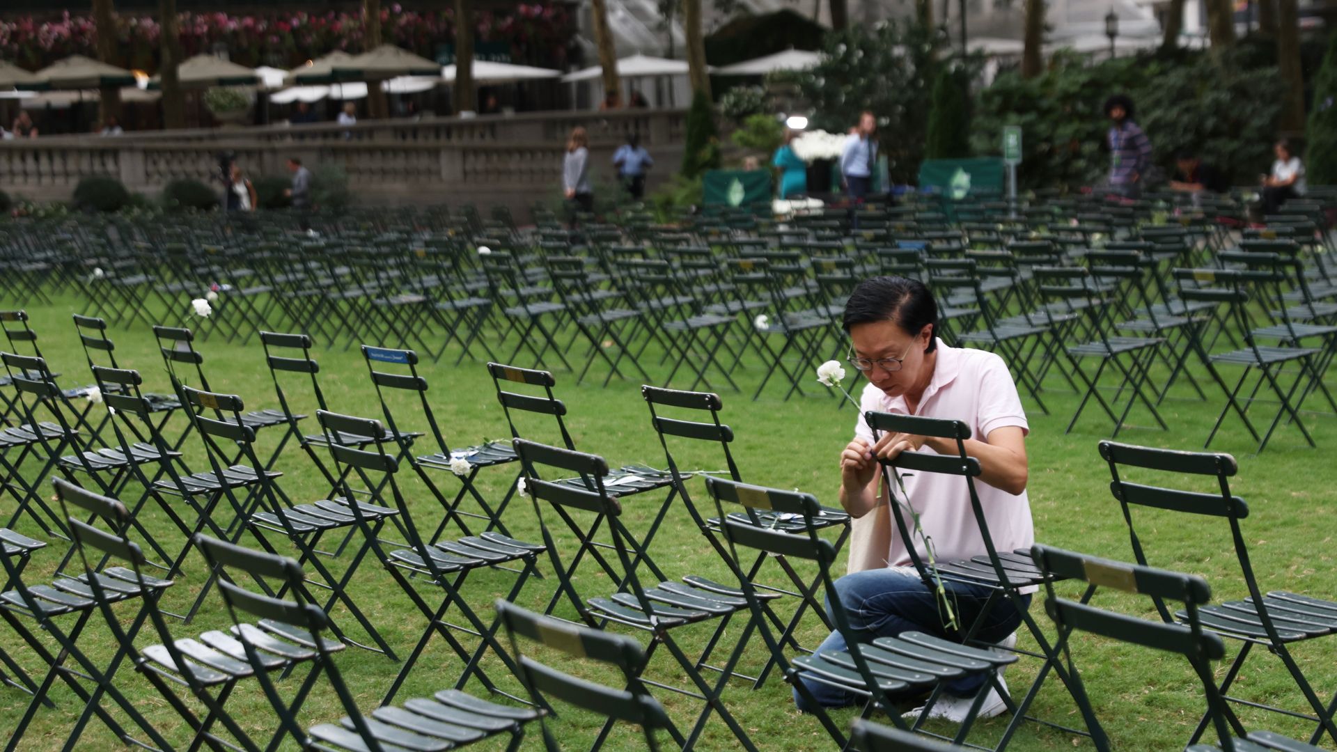 A mourner places a flower on one of 2,753 empty chairs, each signifying a life lost in the terrorist attacks on the World Trade Center on Sept. 11, 2001.