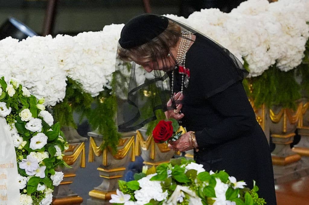 Norway's Queen Sonja places a rose on the coffin of her late husband