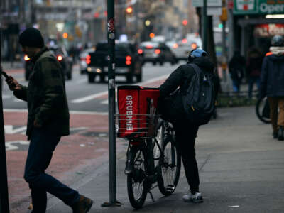 A food delivery person with a bicycle is seen at Times Square in New York City on December 29, 2021.