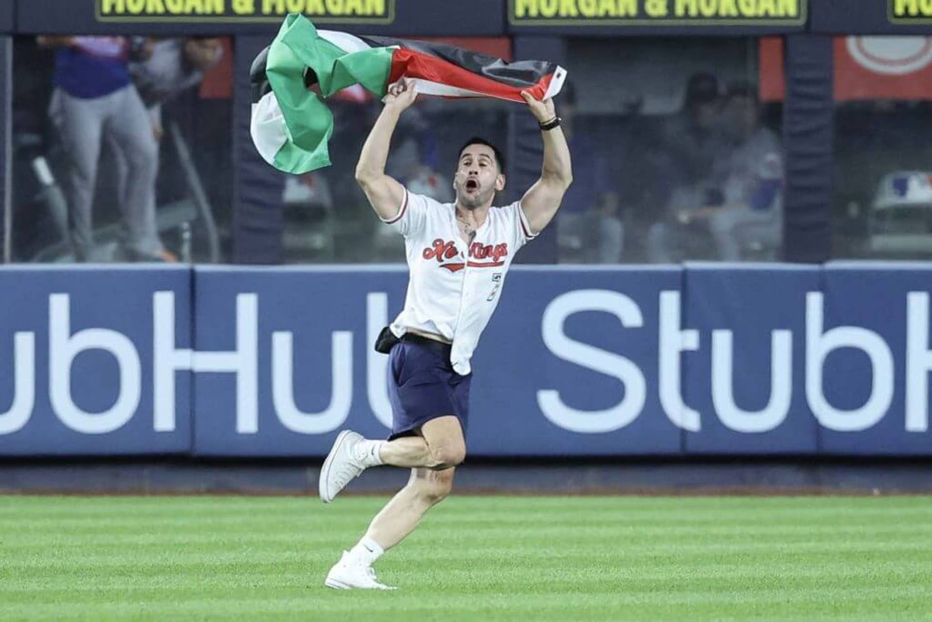 A fan holding a Palestinian flag runs onto the field in the seventh inning during a game between the New York Mets and New York Yankees at Yankee Stadium on the 25th anniversary of 9/11.