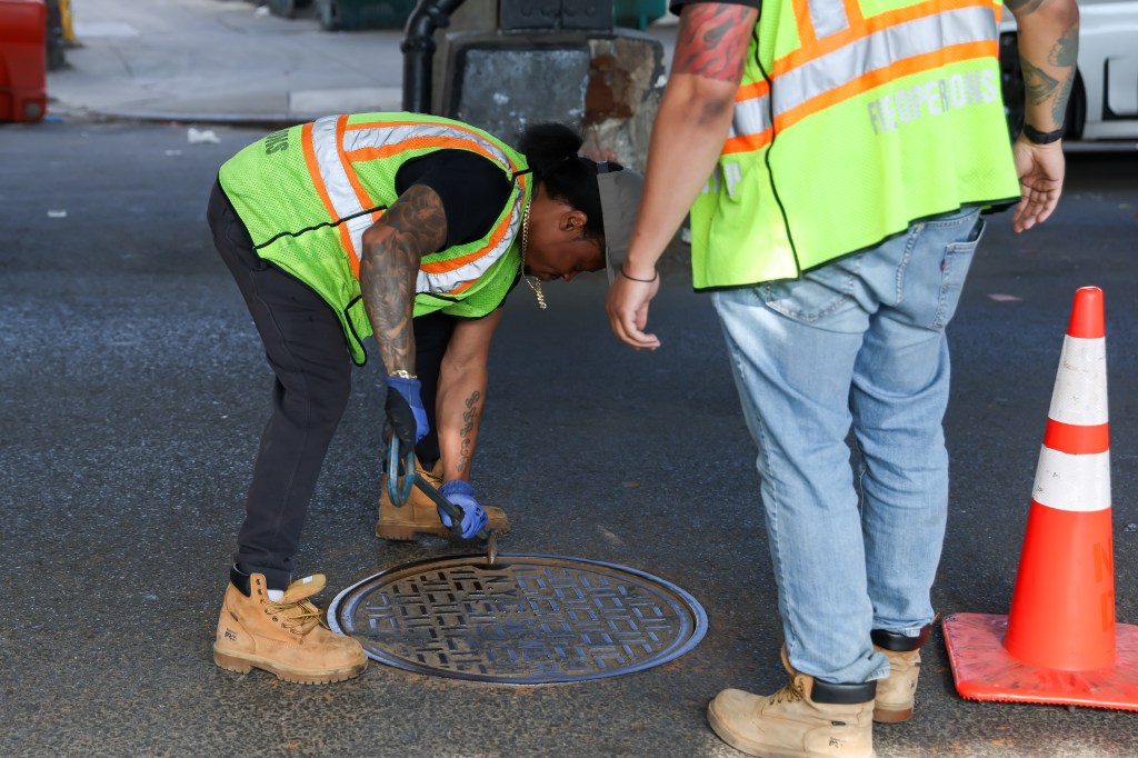 A city worker closes a manhole in Brooklyn. 
